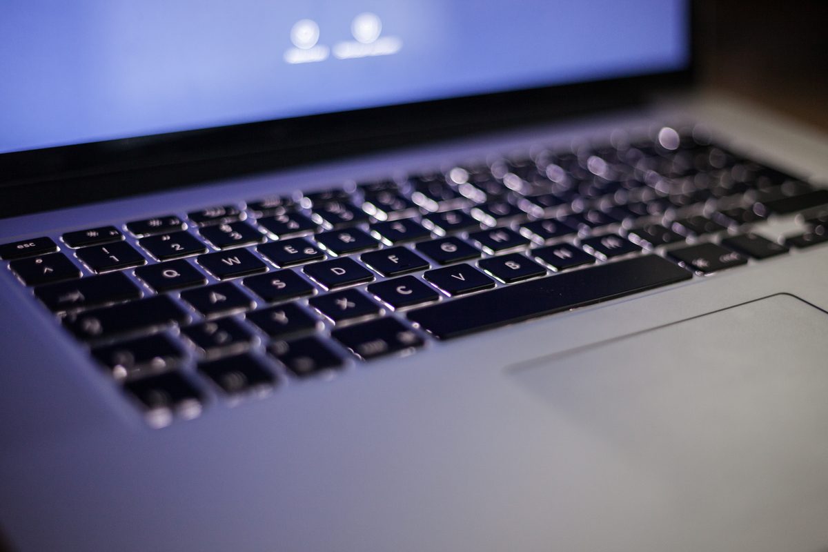 AI chat evidence starts with what you type: a backlit laptop keyboard and glowing laptop screen in a dark room