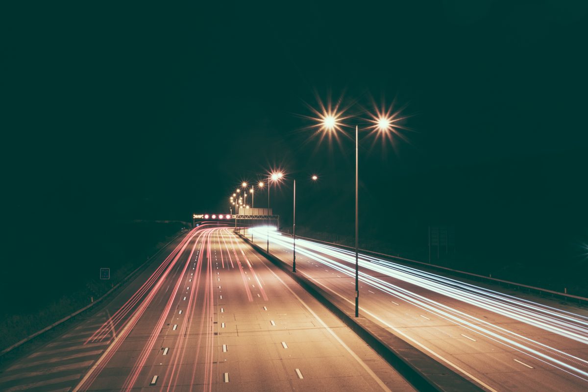 DUI arrest Tampa: light trails from passing traffic on a divided highway under streetlights at night