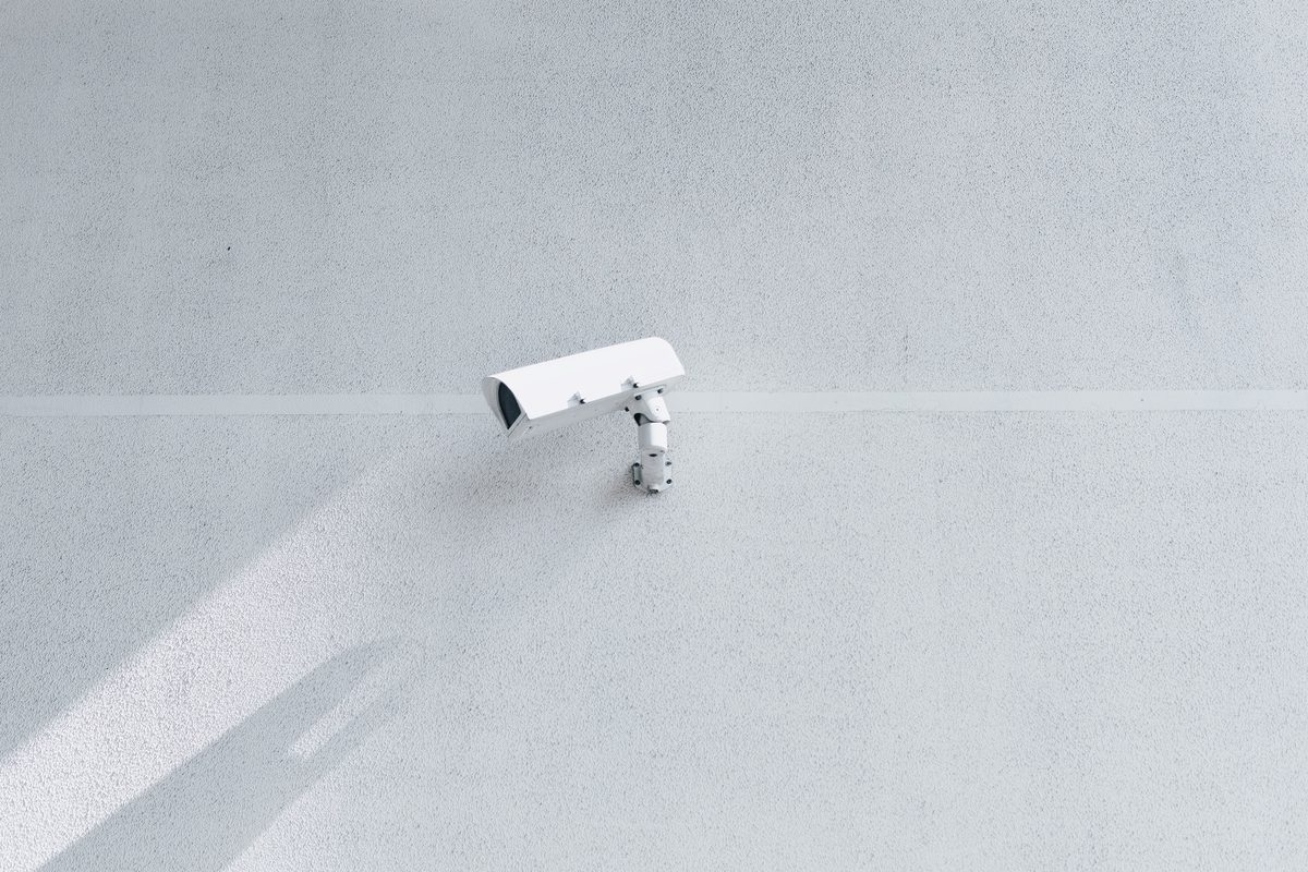 Failure to preserve video evidence: a white surveillance camera on a blank white wall, casting a shadow