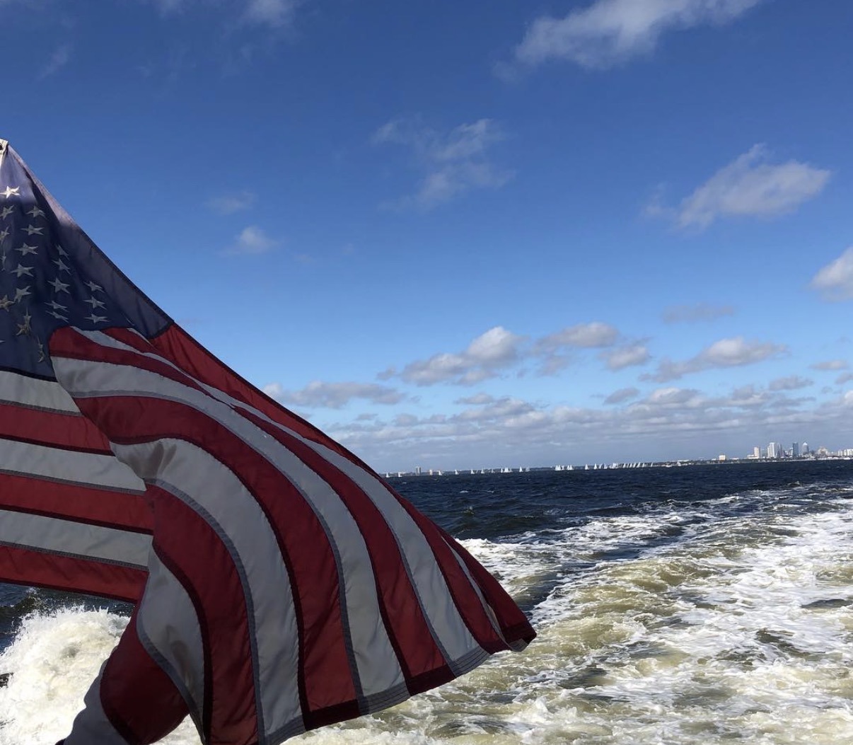 American flag flying off the back of a boat on the water