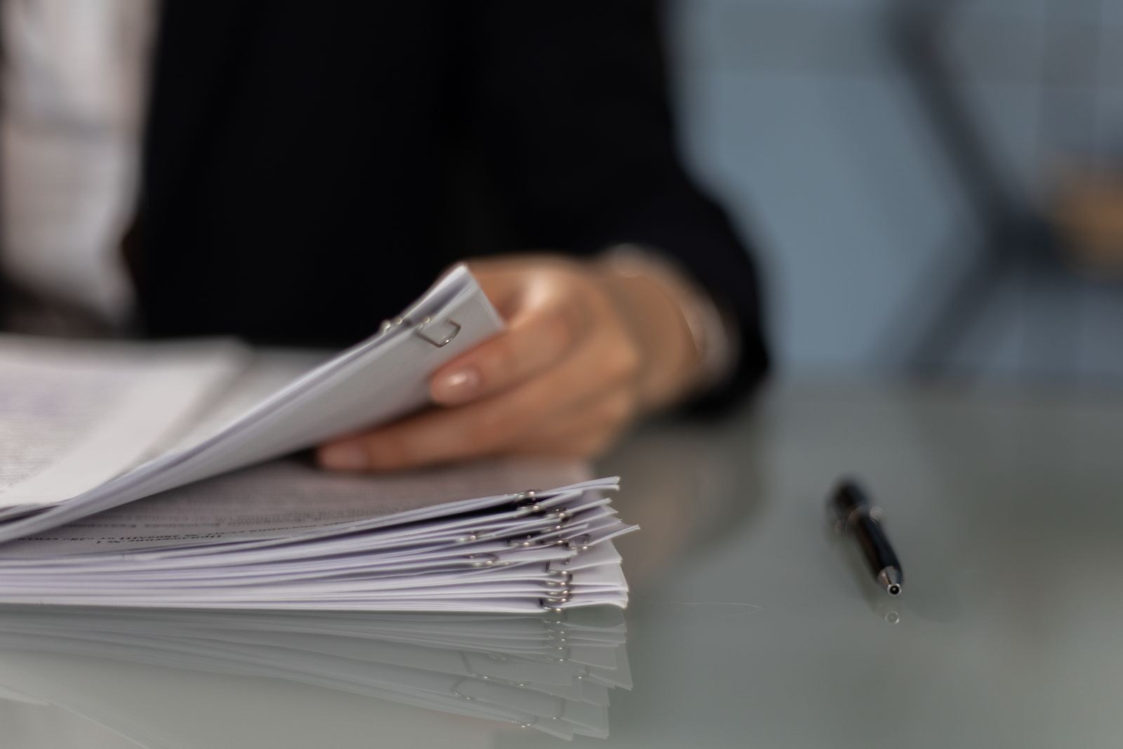 Professional sorting a stack of documents on a desk