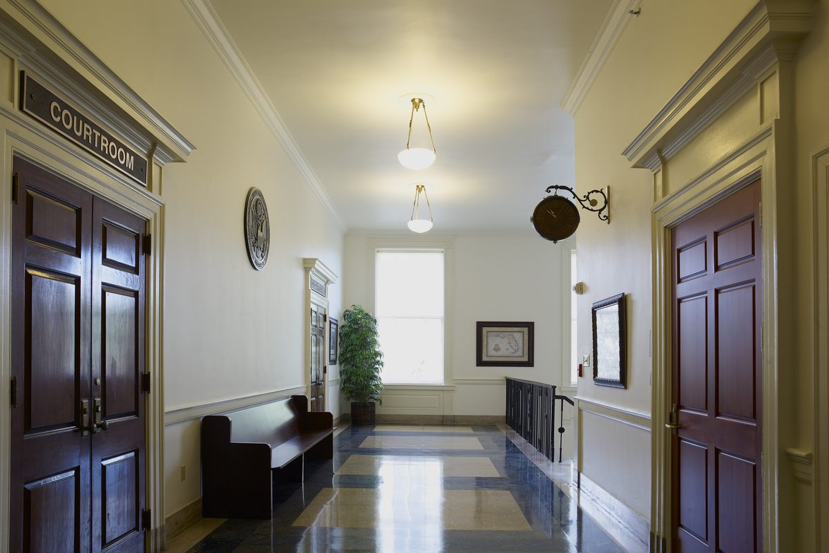Hillsborough pretrial intervention: an empty courthouse corridor with a wooden bench outside the courtroom doors