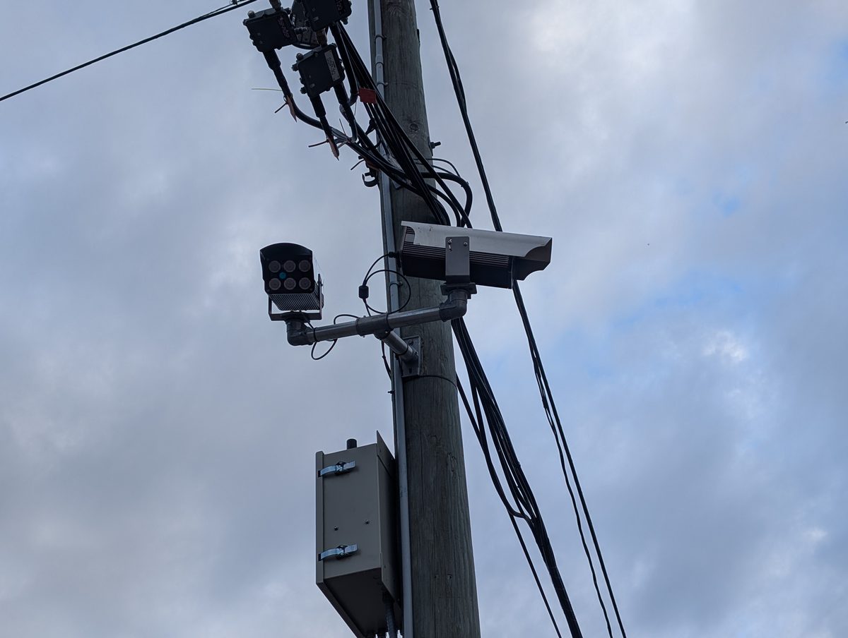License plate reader evidence comes from cameras like these: plate reader units mounted on a utility pole against a cloudy sky