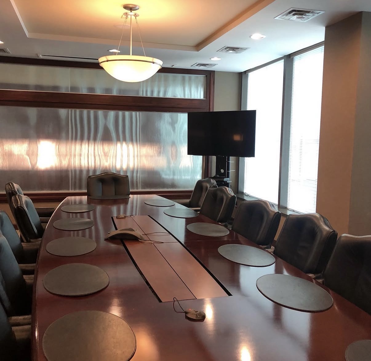 Conference room with a wooden table and wall screen at The Frey Law Firm