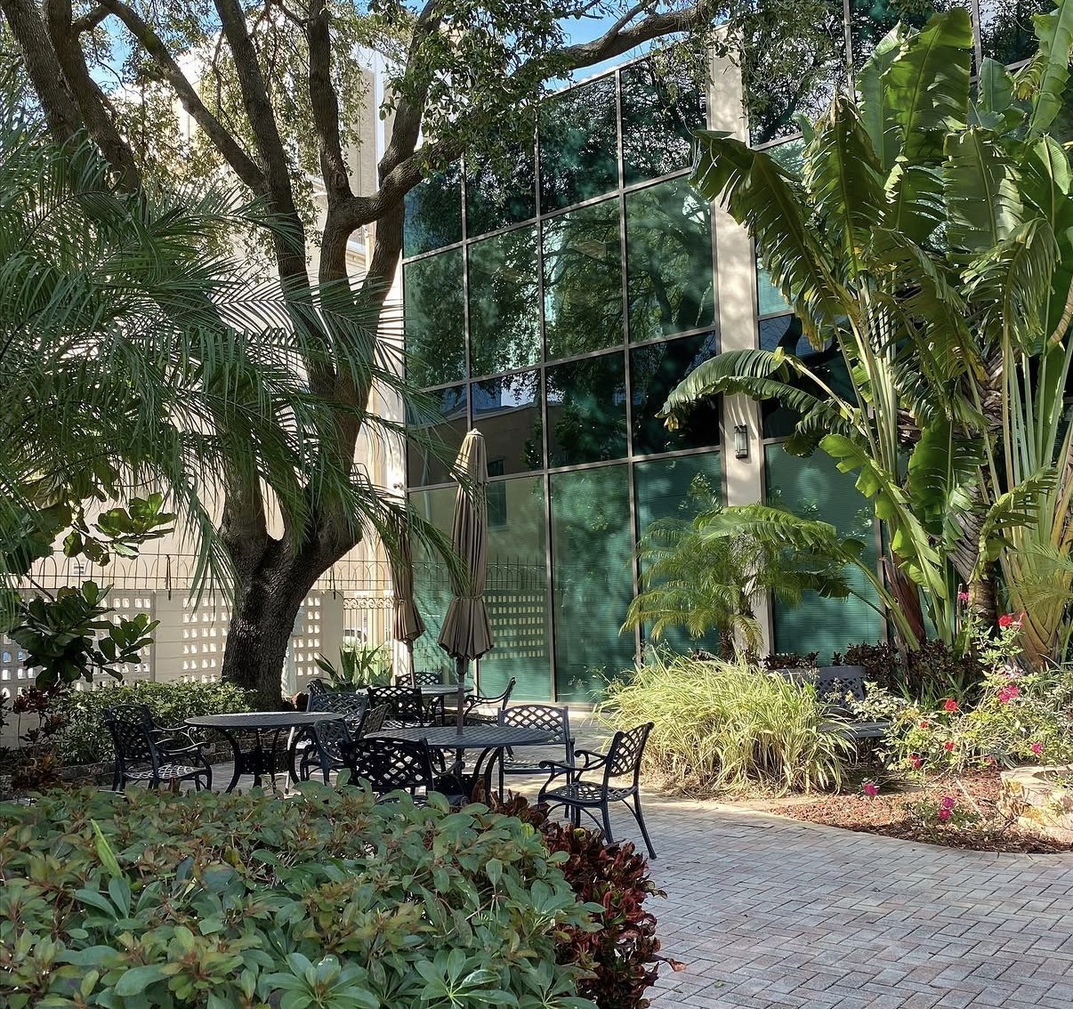 Courtyard with tables and tropical plants outside The Frey Law Firm in downtown Tampa