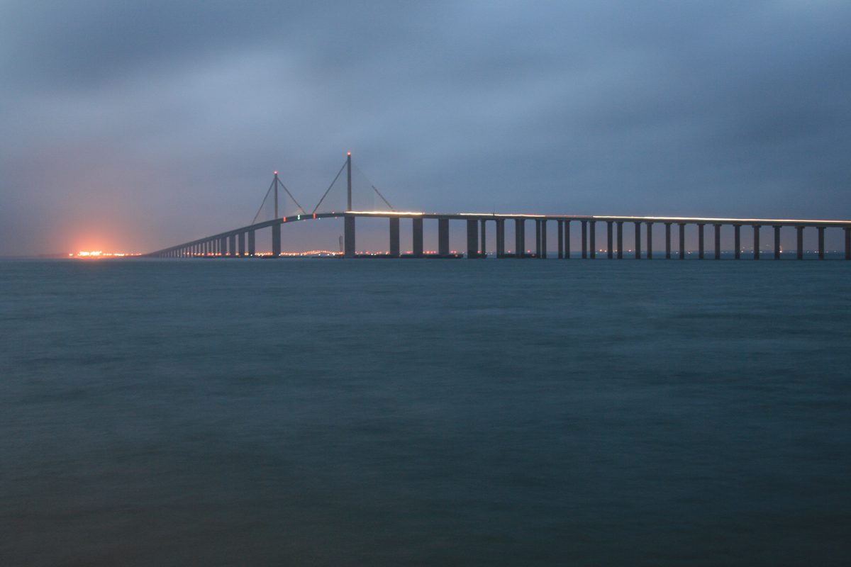Pinellas PTI: the Sunshine Skyway Bridge over Tampa Bay at dusk, seen from the water at the edge of Pinellas County
