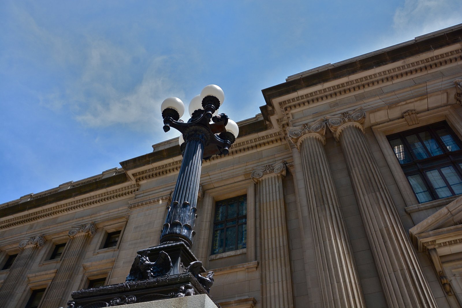 Federal courthouse building with tall stone columns under a blue sky